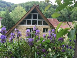 einen Garten mit lila Blumen vor einem Haus in der Unterkunft B&B de charme La Maison des 5 Temps in Ferrette