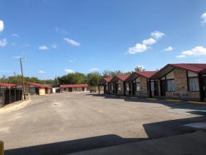 a row of buildings with red roofs in a parking lot at Kings Inn Mexia in Mexia