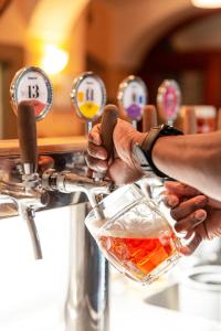 a person is pouring a drink from a tap at Hotel Javor in Adršpach