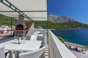 a table with wine glasses on a balcony with a view of the ocean at Dado A6 Apartments in Igrane