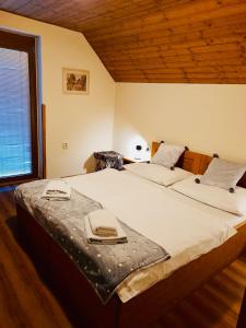 a bedroom with a large bed with two towels on it at Restaurant a penzion Pod Draci skalou in Karlštejn