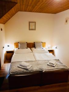 a bedroom with two beds with towels on them at Restaurant a penzion Pod Draci skalou in Karlštejn