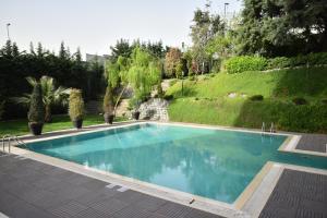 una piscina en un patio con árboles y arbustos en Istanbul Gonen Hotel en Estambul