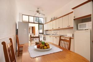 a kitchen with a table with a bowl of fruit on it at Ca na Miquela in El Arenal
