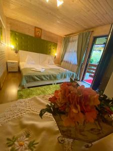 トゥルダにあるPensiunea Edy Turdaのベッドルーム1室(ベッド1台、テーブルの上に花瓶1枚付)