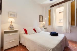 a white bedroom with a white bed and a window at Ca na Miquela in El Arenal