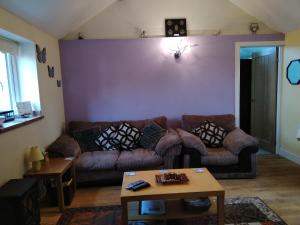 ein Wohnzimmer mit einem Sofa und einem Tisch in der Unterkunft Little Owls Nest Holiday Home in Wisbech