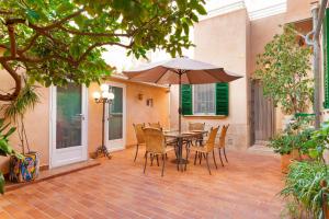 patio ze stołem, krzesłami i parasolem w obiekcie Can Duran w Palma de Mallorca