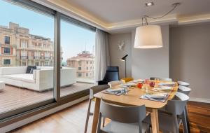 ein Esszimmer mit einem Tisch und Stühlen sowie einem großen Fenster in der Unterkunft Gran View Apartments in Madrid