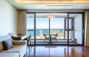 a living room with a view of the ocean at Uni Hotel Jeju in Jeju