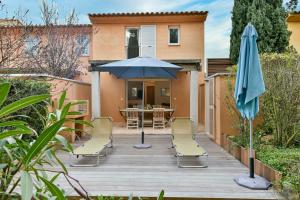 een patio met een tafel, een parasol en stoelen bij CYRNOS in Porto-Vecchio