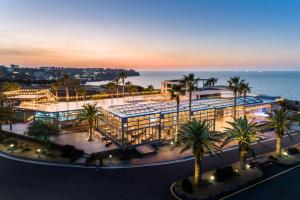 an aerial view of a building with palm trees and the ocean at Uni Hotel Jeju in Jeju