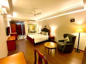 Pokój hotelowy z łóżkiem, krzesłem i stołem w obiekcie Ranbanka Heritage Resort w mieście Bhīlwāra