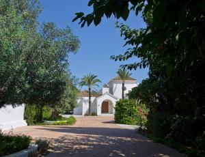 een wit huis met palmbomen en een oprit bij Extravagant 8 BDRM Villa In Marbella, Beachside in Marbella
