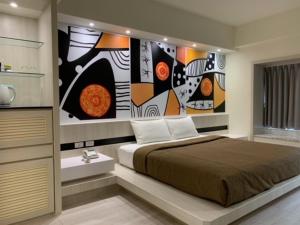Schlafzimmer mit einem Bett mit Wandgemälde in der Unterkunft YHC Hotel in Tainan