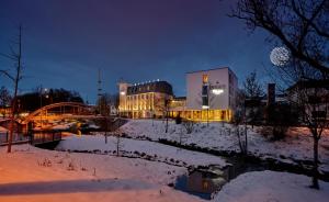 a building with a bridge in the snow at night at Genusshotel Wenisch in Straubing