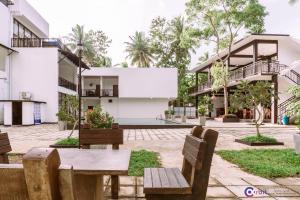 a courtyard of a building with a table and benches at The Grand Pearl Resort in Monaragala