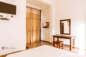 a hotel room with a desk and a mirror at The Grand Pearl Resort in Monaragala