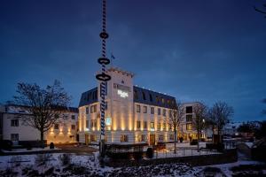 un edificio con un cartel colgando delante de él en Genusshotel Wenisch, en Straubing