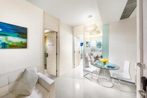 a white living room with a table and chairs at iclub Wan Chai Hotel in Hong Kong