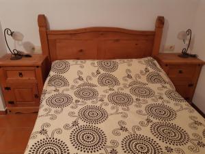 a bed with a black and white comforter and two night stands at Apartamento Fray Eloy de 1 habitacion in Guadalupe