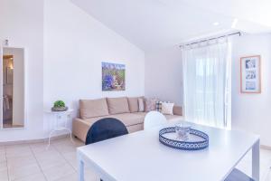 ein weißes Wohnzimmer mit einem Tisch und einem Sofa in der Unterkunft Pinia in Medulin