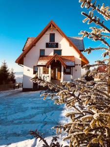 a house in the winter with snow on the ground at Velo Apartamenty in Czorsztyn