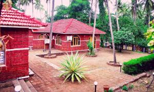 uma pequena casa vermelha com um telhado vermelho em ShriGo Bekal Fort Resort & Spa em Bekal