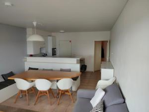 una cucina e una sala da pranzo con tavolo e sedie di Zongericht appartement met zicht op de jachthaven a Ostenda