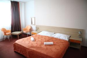 um quarto de hotel com uma cama com duas toalhas em Hotel and Park Divoká Voda em Bratislava