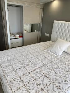 a bedroom with a large white bed and a mirror at Villa Theodora in front of the sea in Hanioti