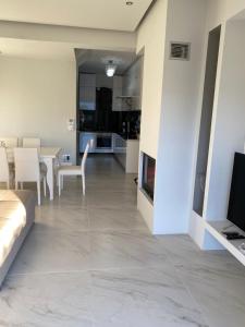 a living room and dining room with a television and a fireplace at Villa Theodora in front of the sea in Hanioti