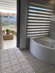 a white bath tub in a room with a window at Villa Theodora in front of the sea in Hanioti +26 photos
