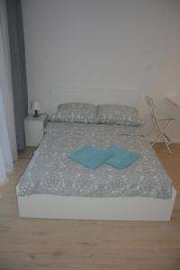a bedroom with a bed with two blue pillows on it at Apartament Royal Place II Jurowiecka 17 in Białystok
