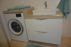 a washing machine in a bathroom with a sink at Apartament Royal Place II Jurowiecka 17 in Białystok