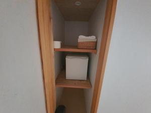 un armario pequeño con estanterías de madera y una cesta en SiEunJae en Gyeongju