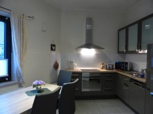 a kitchen with a table and some chairs and a stove at Schlafen & Wohlfühlen in Bremerhaven