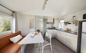 a small kitchen with a white table and chairs at Camping le Mas Fleuri in Sospel