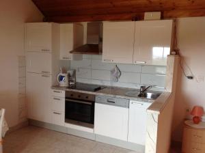 kuchnia z białymi szafkami i zlewem w obiekcie Holiday Home Oliva w Bol