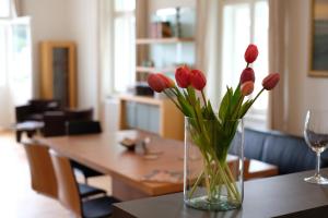 un jarrón de tulipanes rojos sentado en una mesa en Kolonada Luxury 3 bedroom apartment Manes en Mariánské Lázně