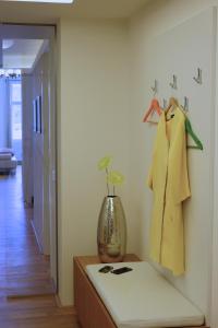 une chambre avec une étagère et deux robes suspendues sur un mur dans l'établissement Kolonada Luxury 3 bedroom apartment Manes, à Mariánské Lázně