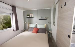 1 dormitorio pequeño con 1 cama grande y ventana en Camping le Mas Fleuri, en Sospel