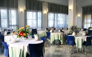 ベッラーリア・イジェア・マリーナにあるHotel Excelsiorの花のテーブルと椅子が並ぶレストラン