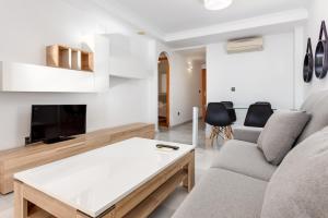 ein Wohnzimmer mit einem Sofa und einem Tisch in der Unterkunft 1st Line Mascarat Beach - Solarium Terrace & Pool in Altea