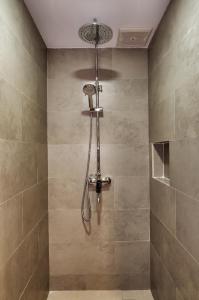 a shower with a shower head in a bathroom at Guest House 555 NKI in Duku