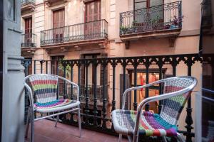 2 sillas sentadas en un balcón frente a un edificio en Hostal Fina, en Barcelona