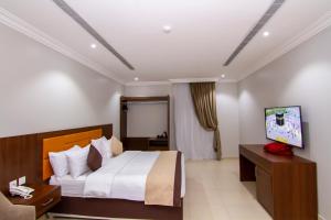 a hotel room with a bed and a television at ال متعب سويتس الفلاح 3 in Riyadh