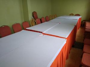 a row of tables in a room with chairs at Crown Hotel Kericho in Kericho