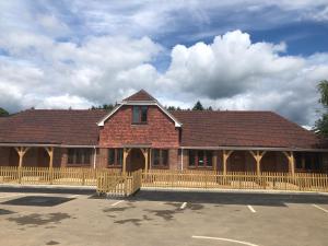 a large brick building with a wooden fence at Hamilton Arms in Midhurst +15 photos