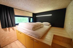 een klein bed in een kamer met een raam bij Forest cube Tradition in Petit Mesnil